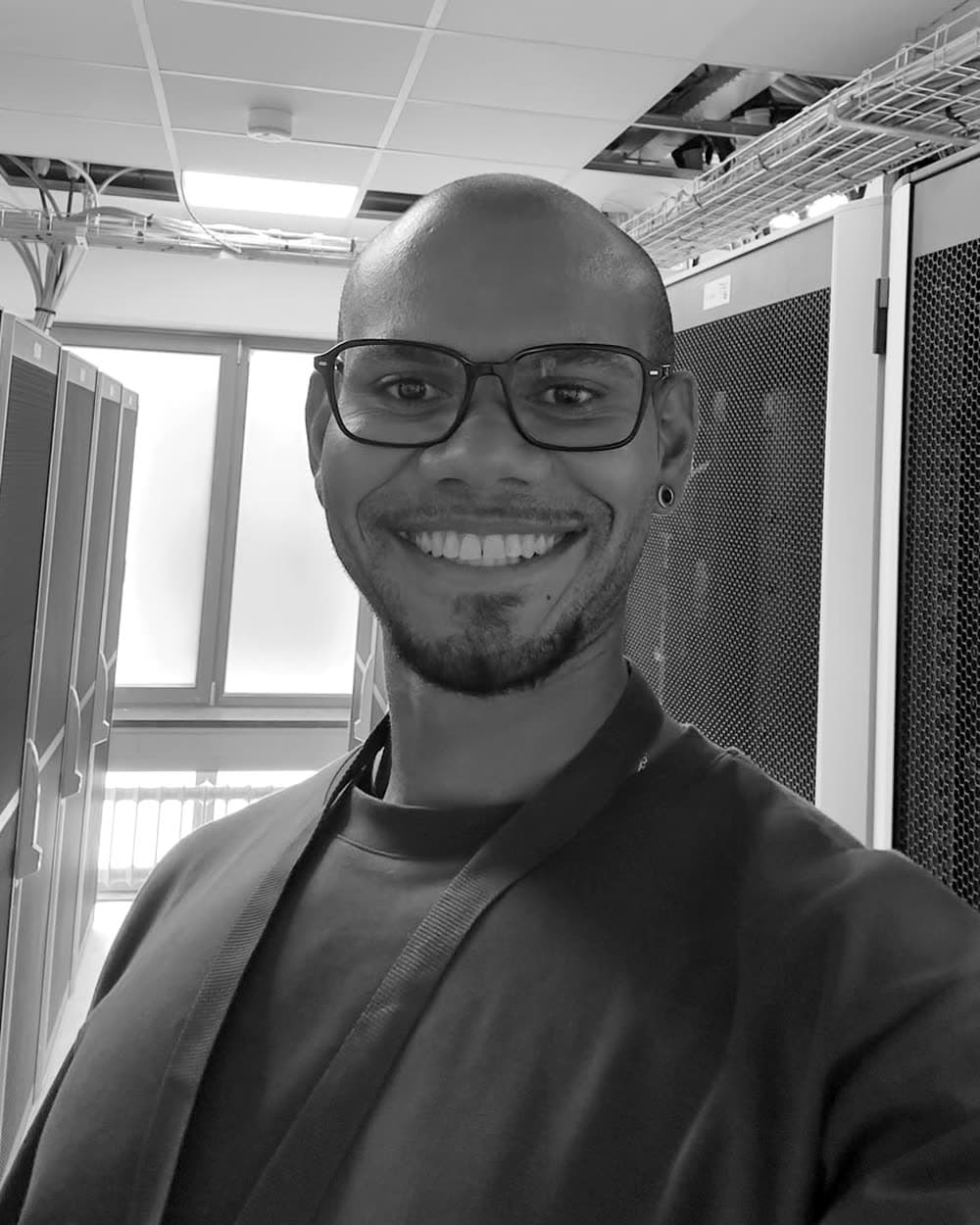 Davino Rosaria in a datacentre, standing in an aisle between server racks.